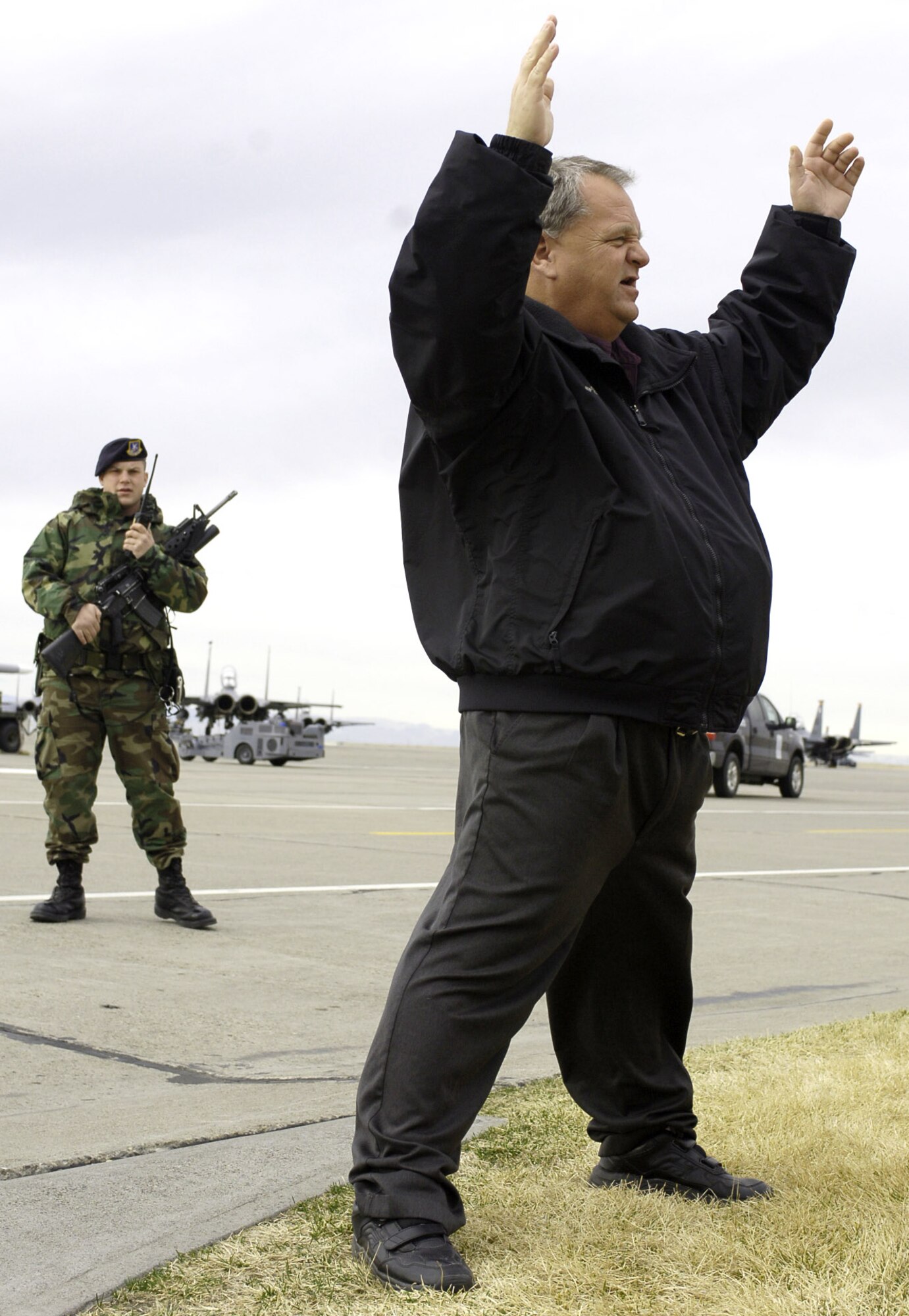 MOUNTAIN HOME AIR FORCE BASE, Idaho – Senior Airman Kyle John, 366th Security Forces Squadron, radios in to the security forces control center before apprehending Gerald Weed during a flightline intrusion exercise Feb. 22. The drill was part of Sharpshooter 07-01 -- a wing-wide mobility and combat readiness exercise which started Feb. 22. Mr. Weed serves with the 366th Fighter Wing’s Plans and Programs Office. Air Force photo by Airman 1st Class Ryan Crane