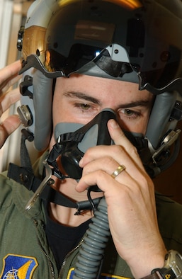 EIELSON AIR FORCE BASE, Alaska -- Captain Jeremey Wimer, 18th Fighter Squadron F-16 pilot, tries on a newly issued flighter helmet while gearing up Feb. 21 at the 18th Fighter Squadron. The new helmet mounted queing system has targeting technology that projects holographic data on the inside right of the visor in the form of a container, or que and allows pilots to continually survey and distinguish between friendly and enemy air and ground targets. ( U. S. Air Force phot by Airman 1st Class Christopher Griffin.)