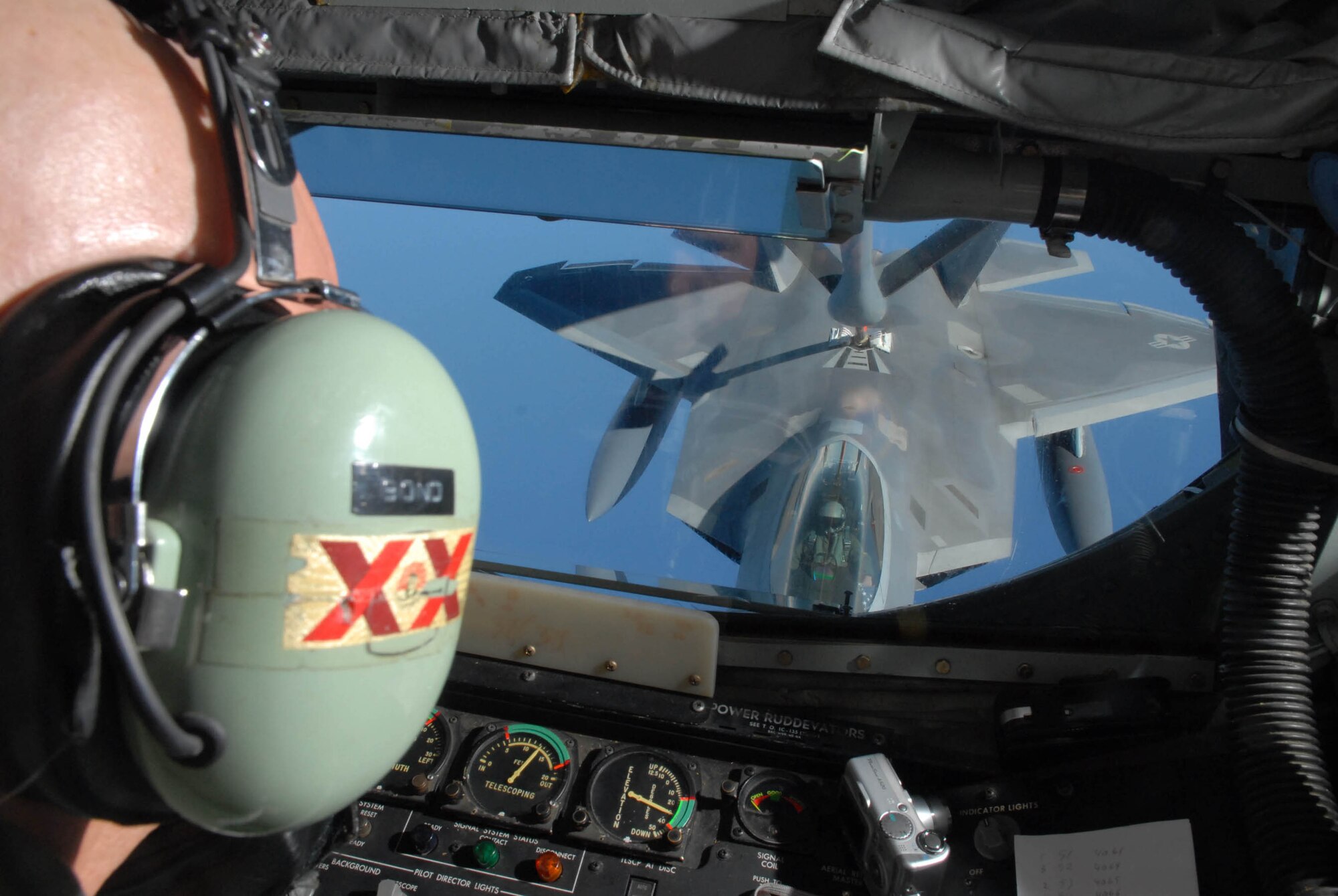 Tech. Sgt. Clifton Bond gives fuel from a 909th Air Refueling Squadron KC-135 to a F-22 Raptor over the Pacific Ocean on Feb. 18 while en route to Kadena Air Base, Okinawa, Japan for the first-ever overseas deployment of the F-22.
Twelve F-22s from the 27th Fighter Squadron deployed to the base as part of the recent Air and Space Expeditionary Force rotation.  Sergeant Bond is a boom operator with the 18th Operations Support Squadron at Kadena.  (U.S. Air Force photo/Senior Airman Jeremy McGuffin)
