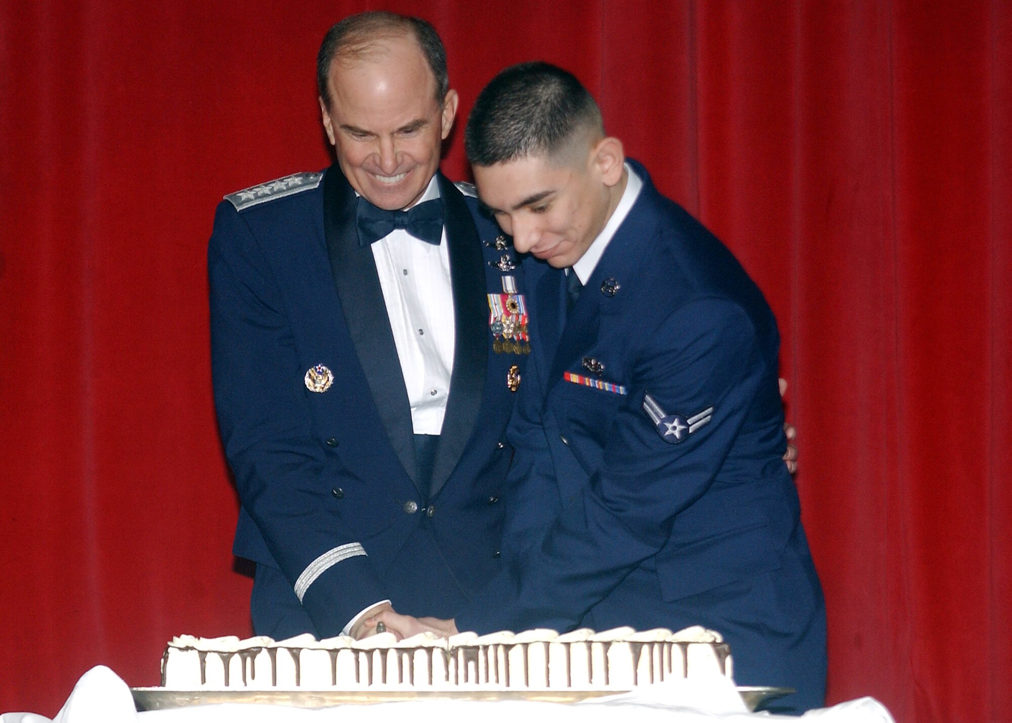Gen. Kevin P. Chilton, Air Force Space Command commander, cuts the ceremonial cake with Airman 1st Class Archie Garcia, 21st Security Forces Squadron. The cake cutting was part of the Air Force Ball held Feb. 2 at the Broadmoor Hotel. (U.S. Air Force photo by Tech. Sgt. Raheem Moore)
