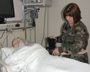 MINOT AIR FORCE BASE, N.D. -- Maj. Ann Perry, 5th Medical Group education and training/readiness flight commander performs a blood pressure check on a SimMan at the skills lab here Feb. 23. A SimMan is a portable and advanced patient simulator for medical training. Major Perry recently won the Air Force's 2006 education and training nurse award. (U.S. Air Force photo by Airman 1st Class Wesley Wright)