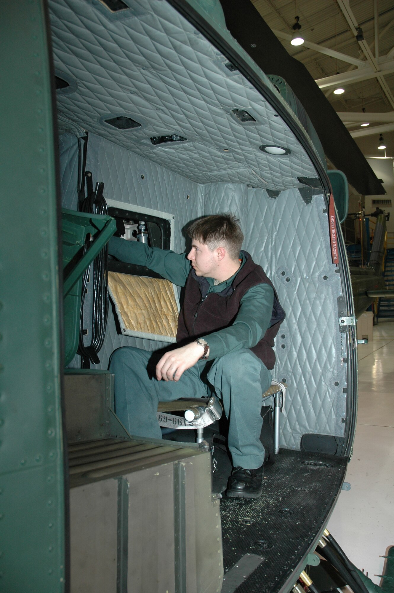 Dallas Robertson inspects the transmission area during a post-flight inspection of a UH-1N Huey assigned to the 40th Helicopter Squadron.