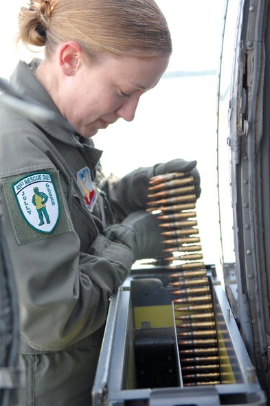 MOODY AIR FORCE BASE, Ga. -- Senior Airman Wendy Stombaugh, 41st Rescue Squadron aerial gunner, loads belts of 7.62mm ammunition into an HH-60G minigun magazine as a part of preflight procedures.  (U.S. Air Force photo by Airman 1st Class Gina Chiaverotti)
