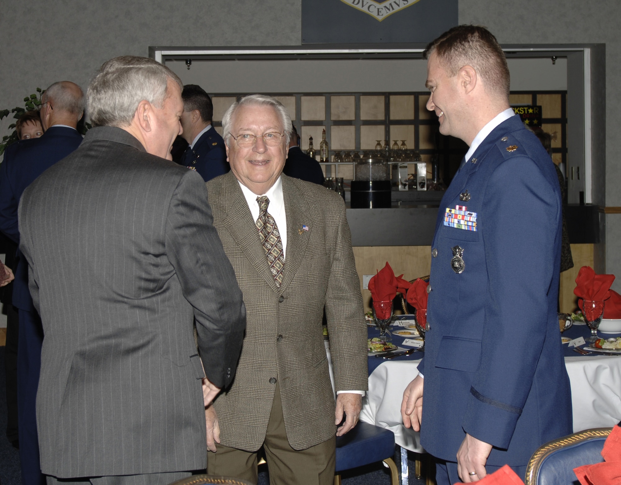 Mike Nelson, newly inducted honorary commander for the 22nd Security Forces Squadron, talks with Golden Eagle Keith Lesher and Maj. Mike Green, 22nd SFS commander during the Annual Honorary Commander's Banquet at McConnell Air Force Base Feb. 22. (Air Force photo by Airman 1st Class Laura Suttles, 22nd Communications Squadron)