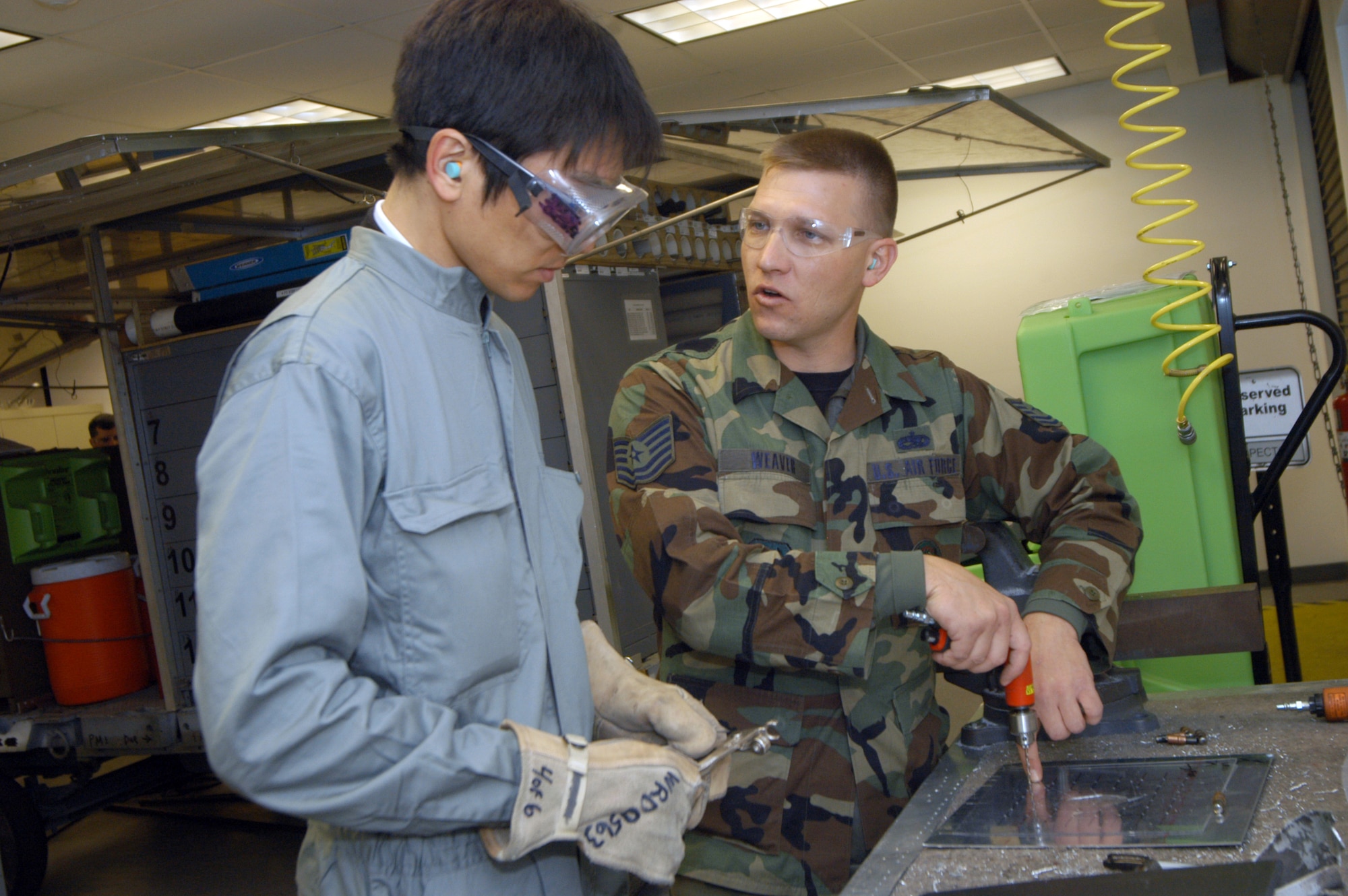 Tomohiro Matsuo, the civilian member among the students, gets instruction from Tech. Sgt. Glen Weaver, 653rd Aircraft Battle Damage Repair training instructor.
