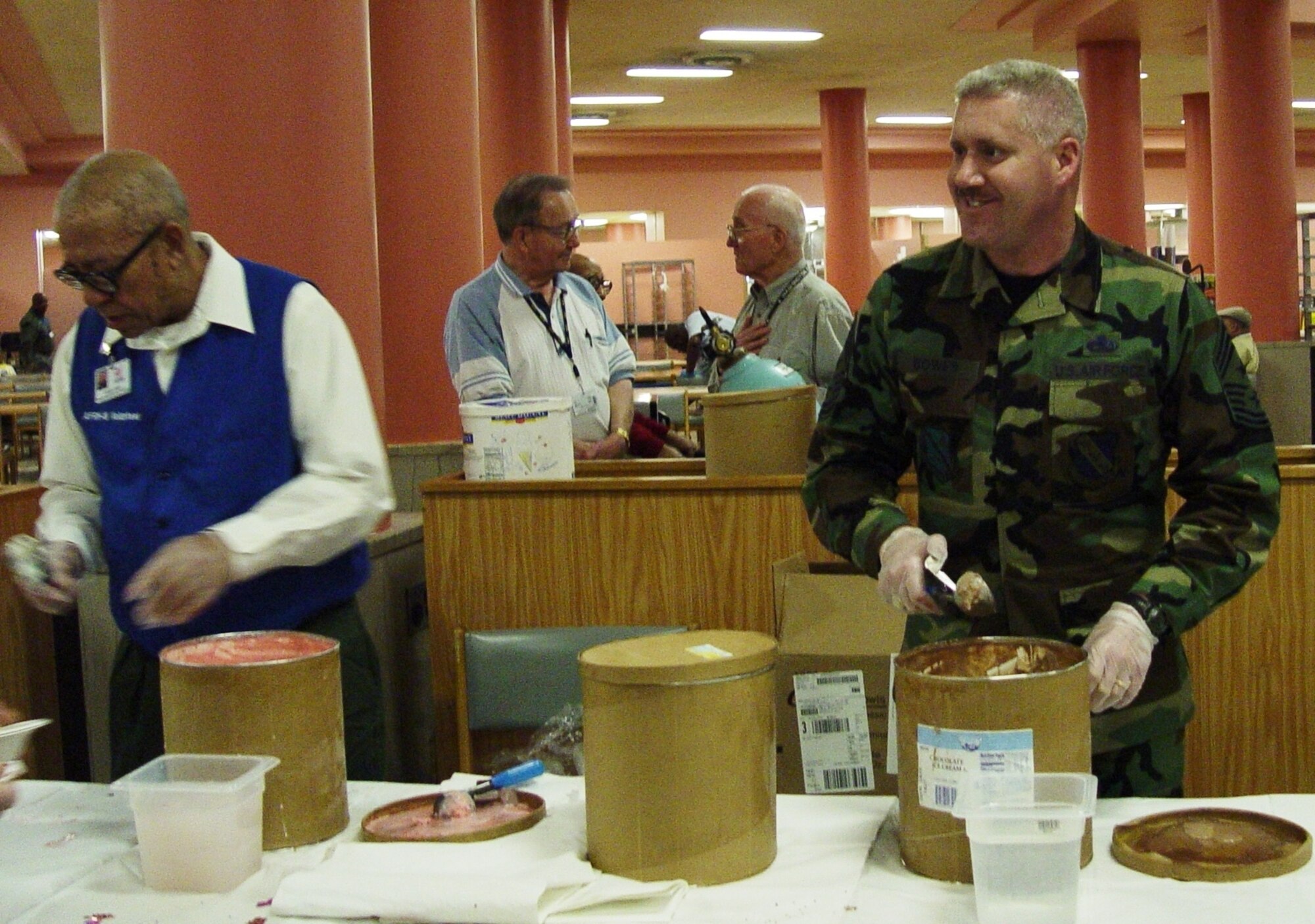 CMSgt. Jeffery K. Bowes, Command Chief MSgt. of 11th Wing, right, is ready to serve ice cream to residents at the Armed Forces Retirement Home in Washington D. C. during the home's monthly ice cream social.  Air Force photo by Capt. Tara Bush