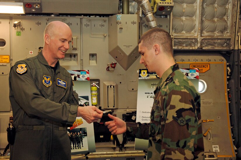Brig. Gen. S. Taco Gilbert, AFSO 21 chief, gives an AFSO 21 coin to Airman Krystopher Johnson, 437th Maintnenance Squadron crew chief, after Airman Johnson's breifing on the phase plus two lean inititiave at Charleston AFB, S.C., Feb. 16. (U.S. Air Force photo/Staff Sgt. April Quintanilla)