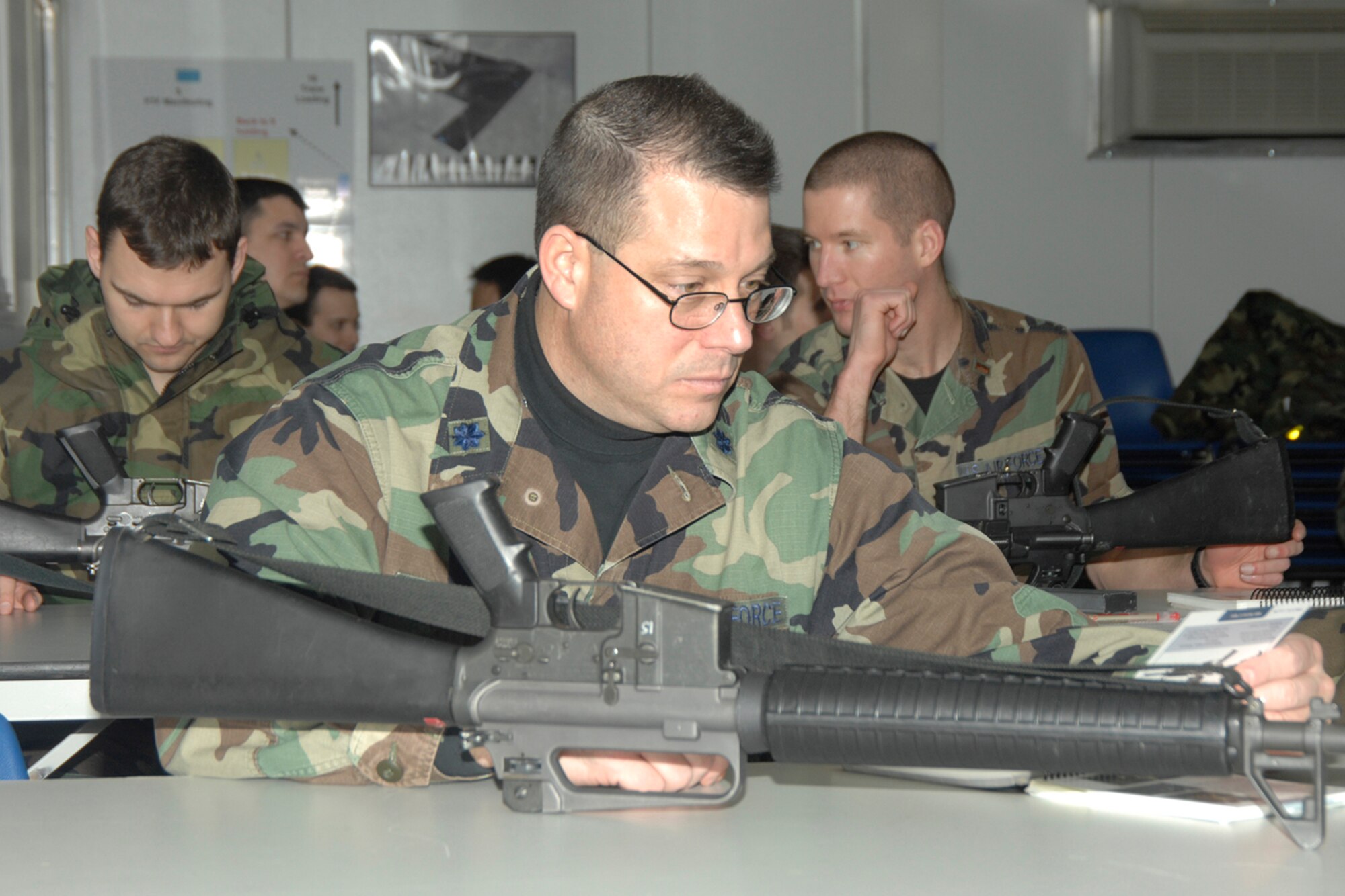 HANSCOM AFB, Mass. -- Lt. Col. Andrew Terzakis, 551st Electronic Systems Wing Weather Systems Division deputy chief, refers to his Airman’s Manual 10-100 (AFMAN 10-100) while disassembling an M-16A2 rifle during a Base Readiness Exercise training session Feb. 15. The information about disassembling the weapon can be found on page 105 in the Airman’s Manual. U.S. Air Force photo by Linda LaBonte Britt