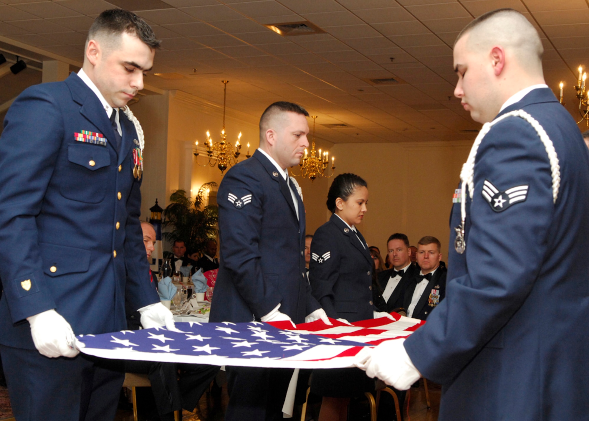 HANSCOM AFB, Mass. -- Members of the recent Airman Leadership School class participate in a flag folding ceremony during their graduation ceremony Feb. 15 at the Minuteman Club. ALS is a five-week course and the first step of Professional Military Education for all enlisted Airmen. The course is required to be taken in residence by active-duty servicemembers prior to being promoted to the rank of staff sergeant and is a requirement for all Airmen to be a rater on Enlisted Performance Reports. U.S. Air Force photo by Mark Wyatt