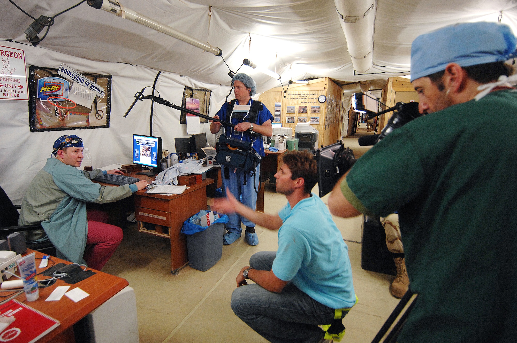 Discovery Channel videographer Joel Schwarzberg (right), producer Brent Henderson (kneeling), and sound mixer Kenny Liston (standing), conduct an interview Feb. 22 with Lt. Col. (Dr.) Jerry Pratt, a cardio-thoracic surgeon for the Air Force Theater Hospital at Balad Air Base, Iraq. The production crew is capturing imagery and interviews for the Discovery Channel series, "Surgery Saved My Life," scheduled to air in June. Colonel Pratt is with the 332nd Expeditionary Medical Group. (U.S. Air Force photo/Master Sgt. Scott Reed)