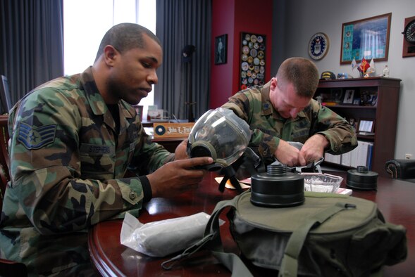 HANSCOM AFB, Mass. -- From left, Staff Sgt. Michael Stephens, 66th Mission Support Group information manager, and 66 MSG Vice Commander Lt. Col. John Parker conduct inspections of their gas masks Feb. 20. According to page 212 of the Airman’s Manual (AFMAN 10-100) masks inspections should be completed every six months during peacetime. (U.S. Air Force photo by Airman 1st Class Clinton Atkins)