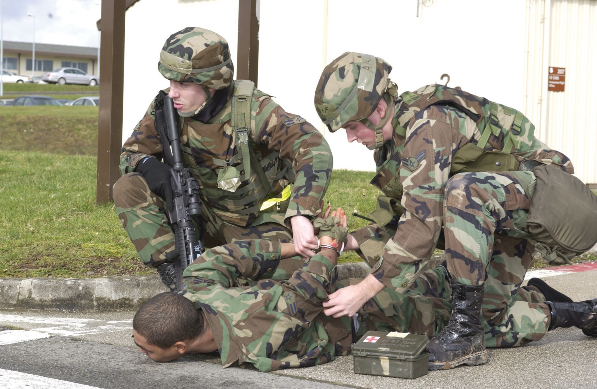 Two Airmen “detain” and provide self-aid buddy care for a role player during the Phase II exercise. Read more about the Phase II and the exercise evaluation team’s role in. (US Air Force photo by Senior Airman Kristin Ruleau)