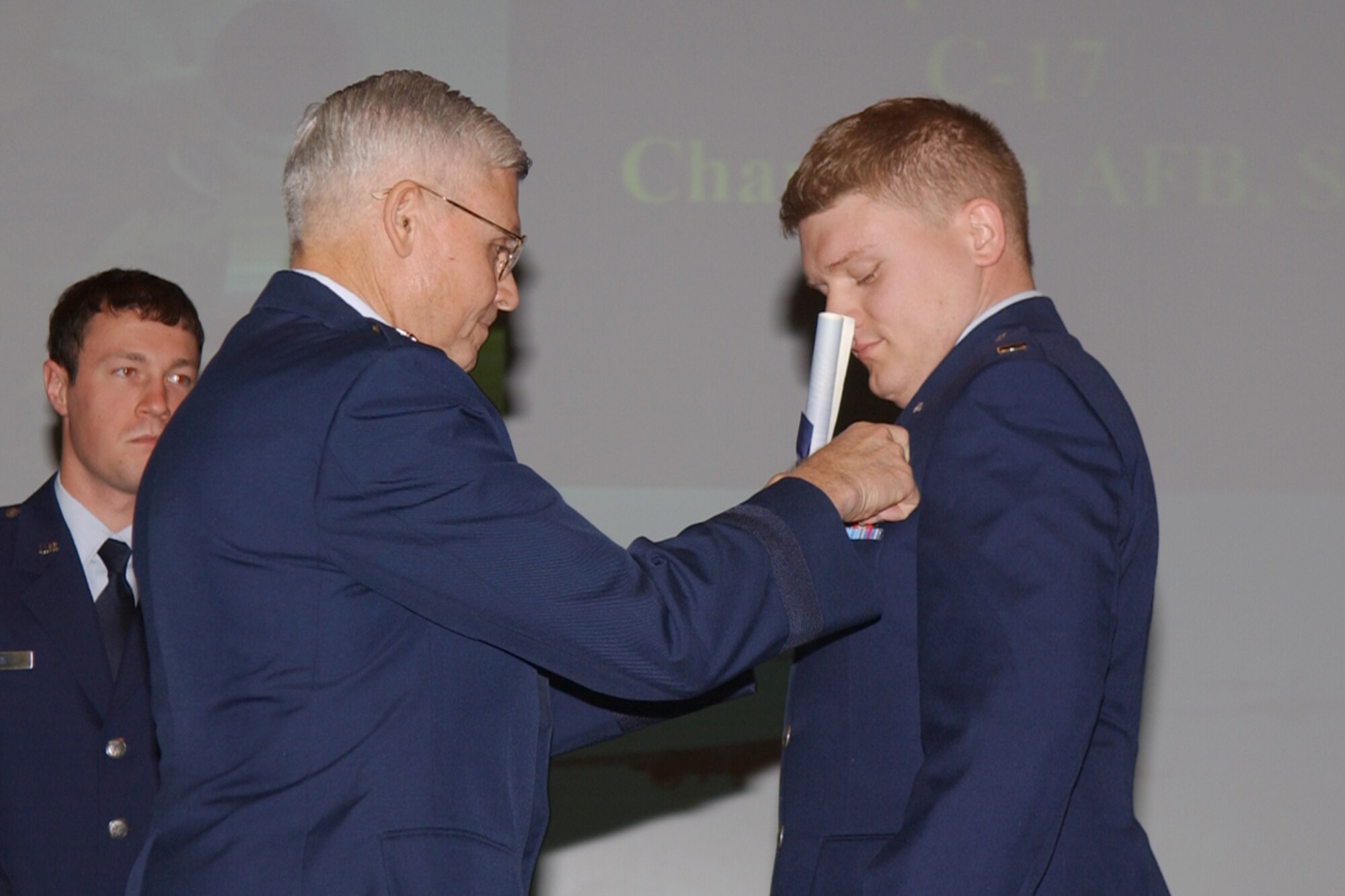 Major General Quentin L. Peterson, Director of Operations, Headquarters Air Mobility Command, Scott Air Force Base, Ill., pins on his son's first set of silver wings Feb. 16. Second Lt. Christopher Peterson was one of 20 graduating members of Specialized Undergraduate Pilot Training Class 07-05. (U.S. Air Force Photo)