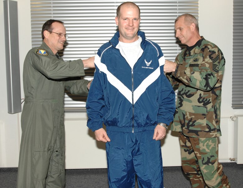 Brig. Gen. Rich Johnston, KMC and 86th Airlift Wing commander, and Chief Master Sgt. Harry Viel, 86th AW command chief, pin stripes on Master Sgt. Jeff Smith, who was promoted from technical sergeant under the Stripes for Exceptional Performers program. Photo by Airman Erin Peterson
