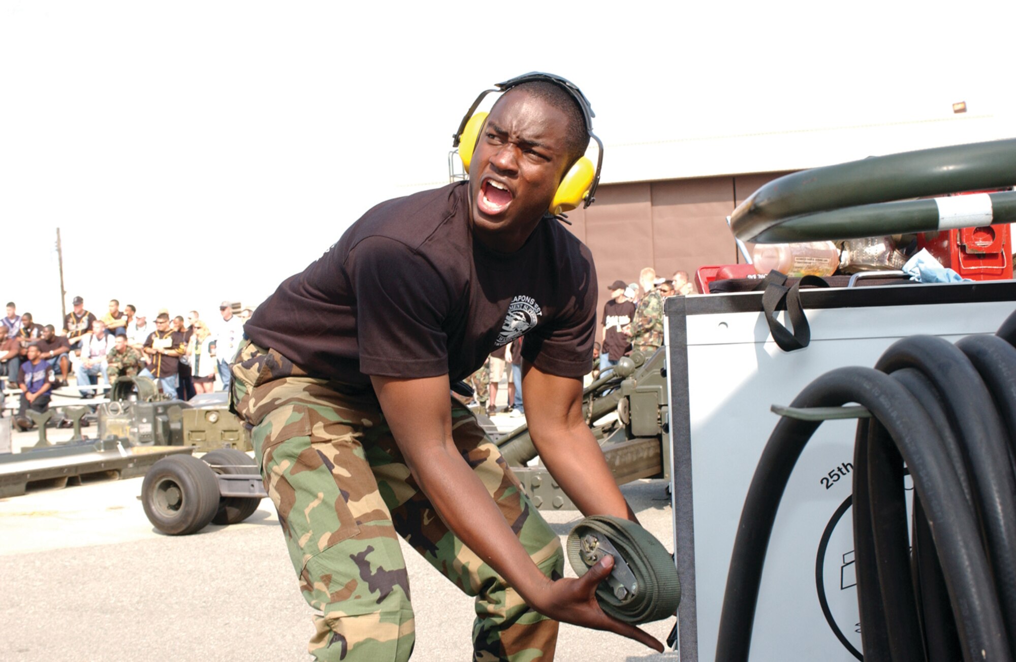 OSAN AIR BASE, Republic of Korea --  Airman Terrance Davis, 51st Aircraft Maintenance Squadron, yells to his teammates as he puts equipment away.  Having finished mounting weapons during the Weapons Load Competition, Airman Davis ensures all the equipment is placed in the correct spot during the timed competition Saturday. (U.S. Air Force photo by  Staff Sgt. Chris Marasky)