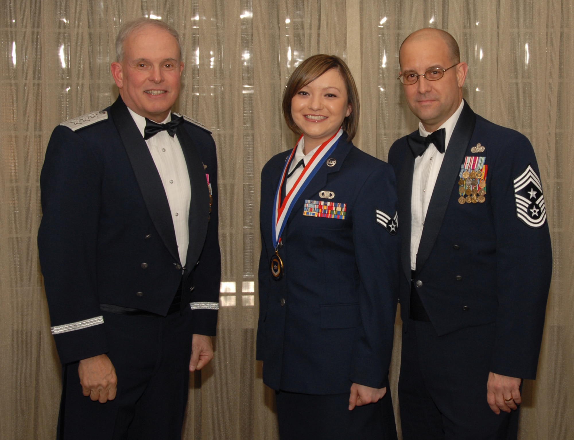 OSAN AIR BASE, Republic of Korea --  Senior Airman Myranda Hinguanzo, 8th Operational Support Squadron, is the 7th Air Force annual winner in the Airman of the Year category. Here she poses with Lt. Gen. Stephen Wood, 7th AF commander, and Chief Master Sgt. Raymond Allen III, 7th AF command chief.