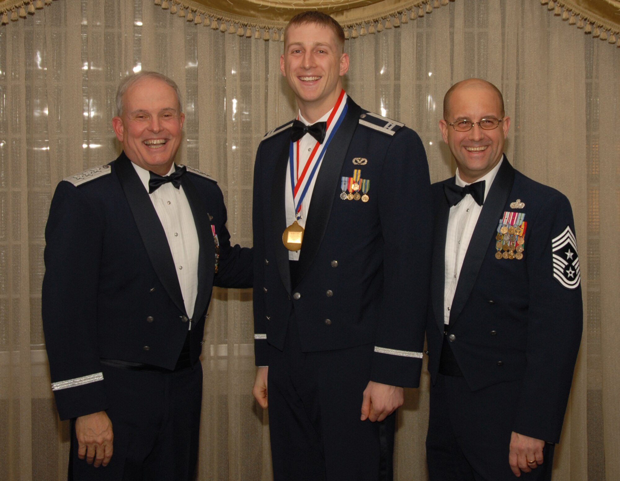 OSAN AIR BASE, Republic of Korea --  Capt. Ryan Crowley, 8th Fighter Wing, is the 7th Air Force annual award winner for the Company Grade Officer category. Here he poses with Lt. Gen. Stephen Wood, 7th AF commander and Cheif Master Sgt. Raymond Allen III, 7th AF command chief.