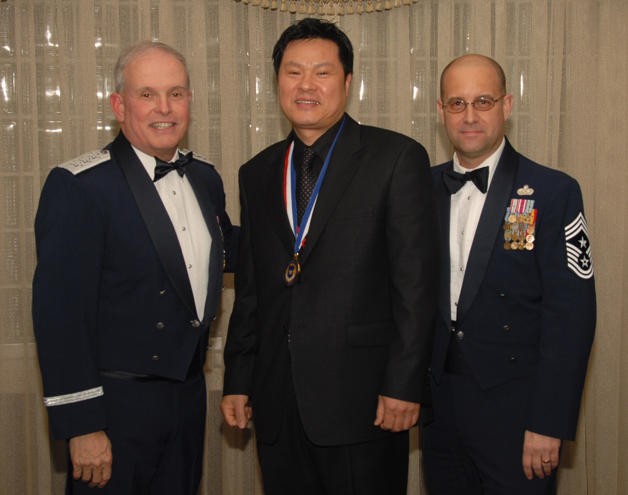 OSAN AIR BASE, Republic of Korea --  Mr. Kim, Song Yul, 51st Services Squadron, is the 7th Air Force annual award winner for the Civilian Trades/Crafts/Laborer category. Here he poses with Lt. Gen. Stephen Wood, 7th AF commander, and Chief Master Sgt. Raymond Allen III, 7th AF command chief.