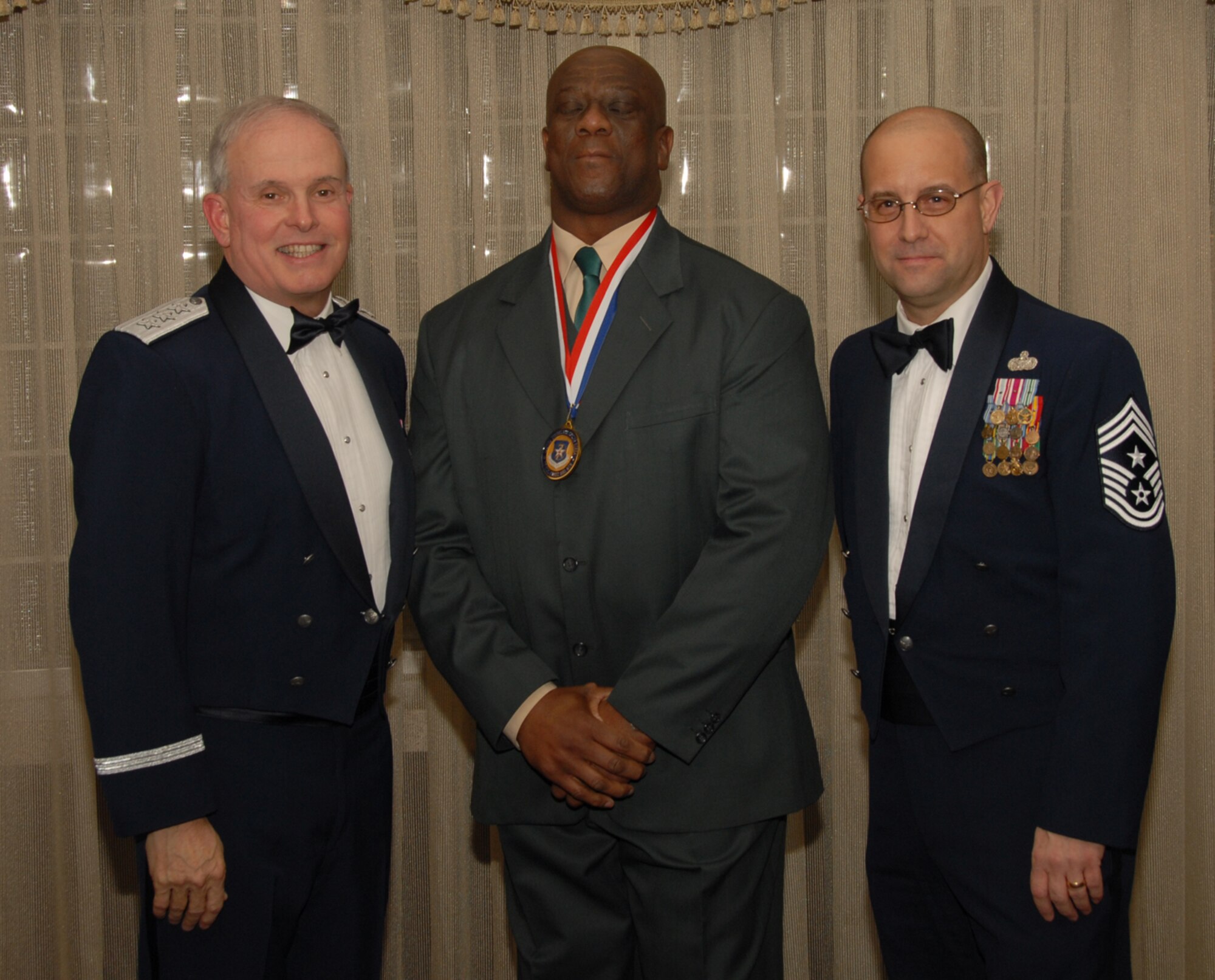 OSAN AIR BASE, Republic of Korea --  Mr. Jimmy Genesy, 51st Medical Support Squadron, is the 7th Air Force annual award winner in the Civlian Administration/Technical category. Here he is posing with Lt. Gen. Stephen Wood, 7th AF commander, and Chief Master Sgt. Raymond Allen III, 7th AF command chief. (U.S. Air Force photo by Staff Sgt. Chrissy Fitzgerald)