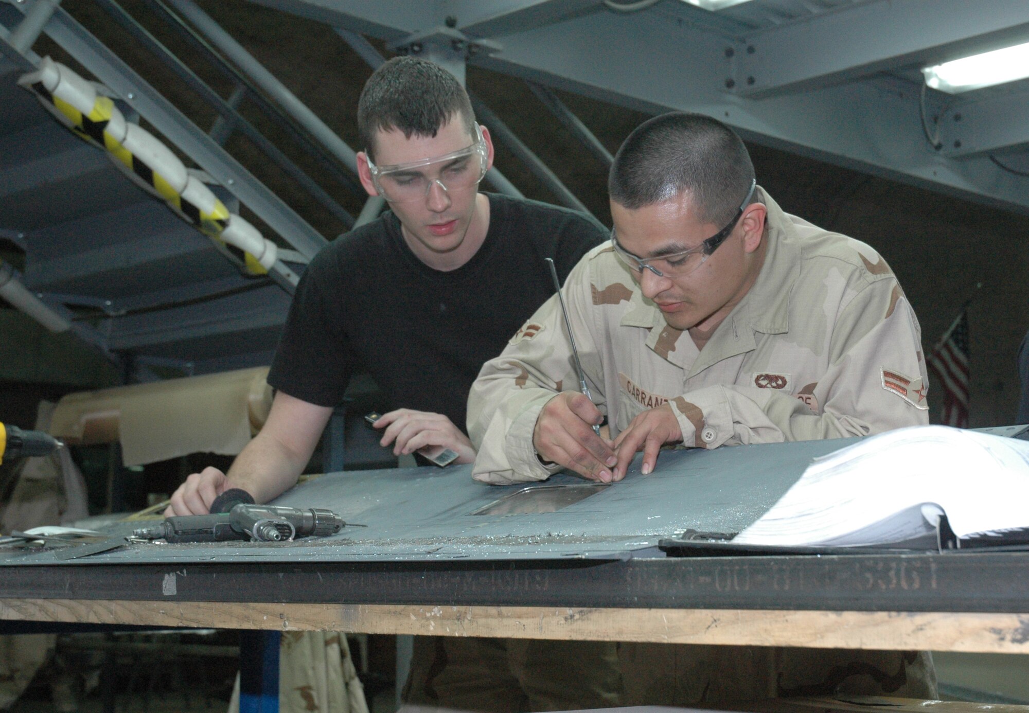 Senior Airman Ryan VanArtsdalen (left) and Airman 1st Class Jaime Carranza (right), 379th EMXS aircraft structural maintenance journeymen, repair a No. 2 spoiler off of a KC-135 Stratotanker. (U.S. Air Force photo by Senior Airman Erik Hofmeyer)

