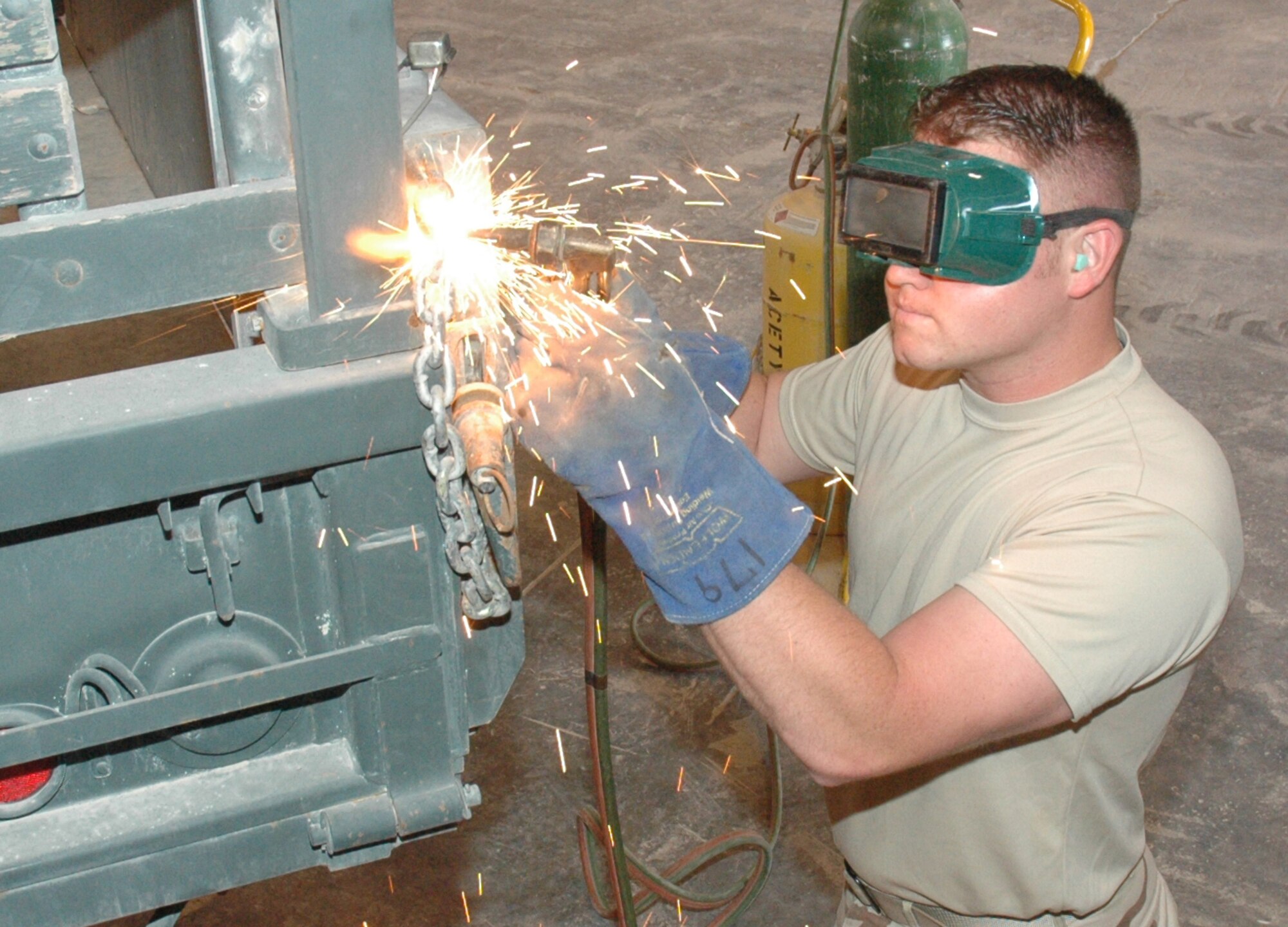 Staff Sgt. Scott Crim, 1st ERHG vehicle maintenance craftsman, cuts off old brackets with an acetylene torch in the back of a M-35 A2 truck. (U.S. Air Force photo by Senior Airman Erik Hofmeyer)