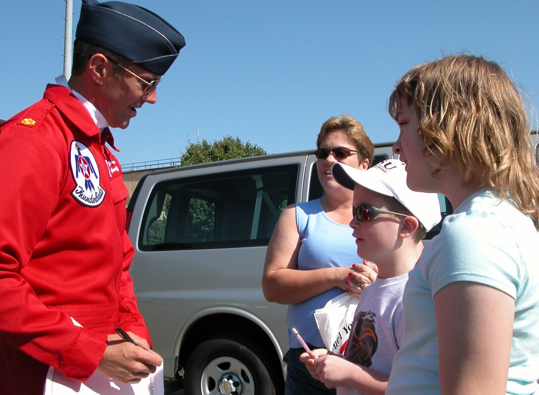 Maj. Jeremy Sloane, a member of the Air Force Thunderbirds, signs his autograph for Open House attendees (From left to right) Brenda, Tyler and Autumn Dankenbring May 21 at Andrews Air Force Base, Md. Photo by Gerry J. Gilmore