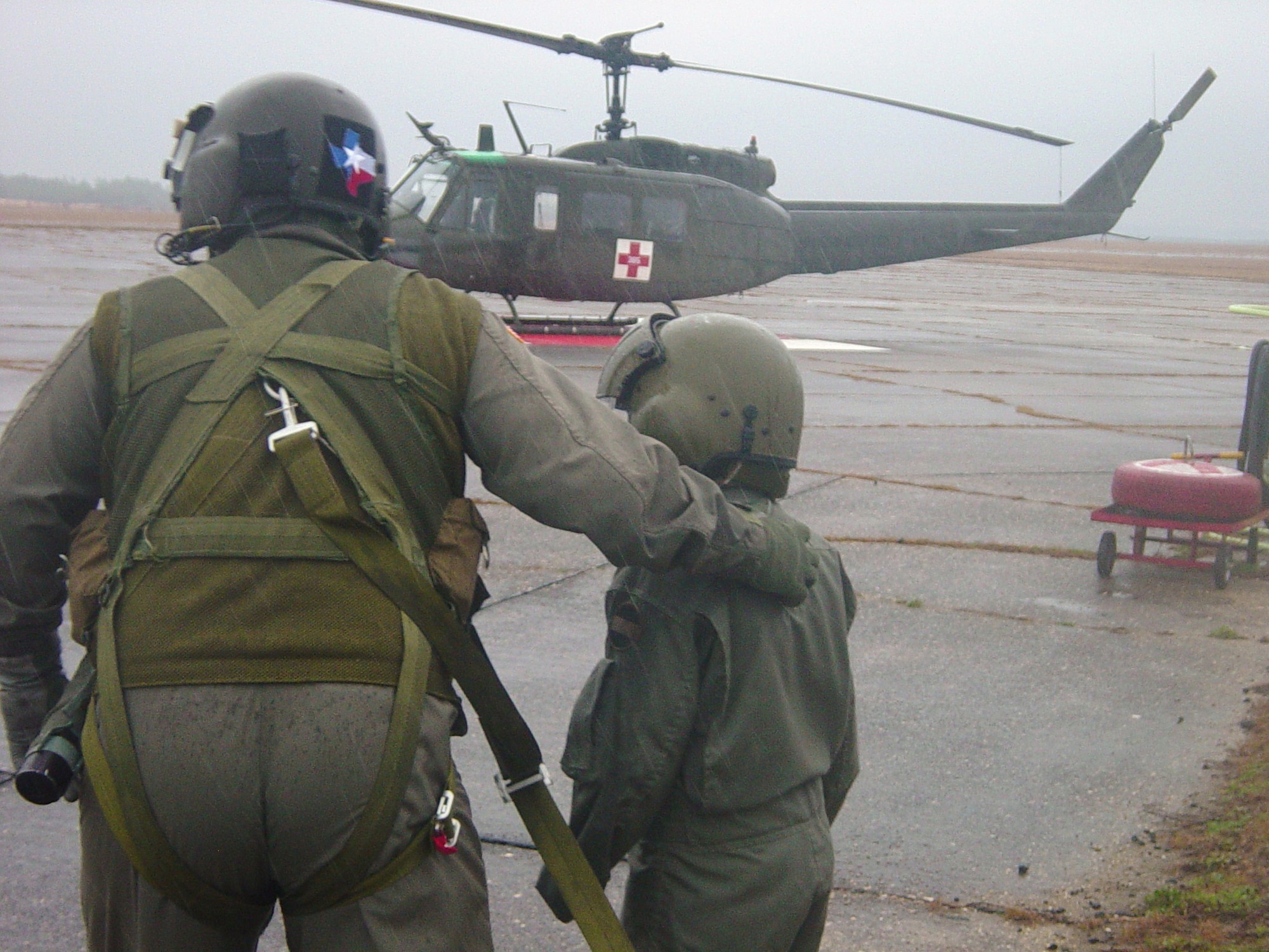 CAMP RUDDER, Fla. -- Riley Woina, 14, from Connecticut, runs through the rain with an air crew member of the 5th Aviation Battalion, Air Ambulance Detachment, Ft. Polk, La., to board a UH-1V Huey helicopter Feb. 21. Riley diagnosed with cystic fibrosis, was granted a week with the 6th Ranger Training Battalion and Eglin Airmen through the Make-A-Wish Foundation Feb. 19-24. (U.S Army photo by Army Capt. Jeremiah Cordovano)
