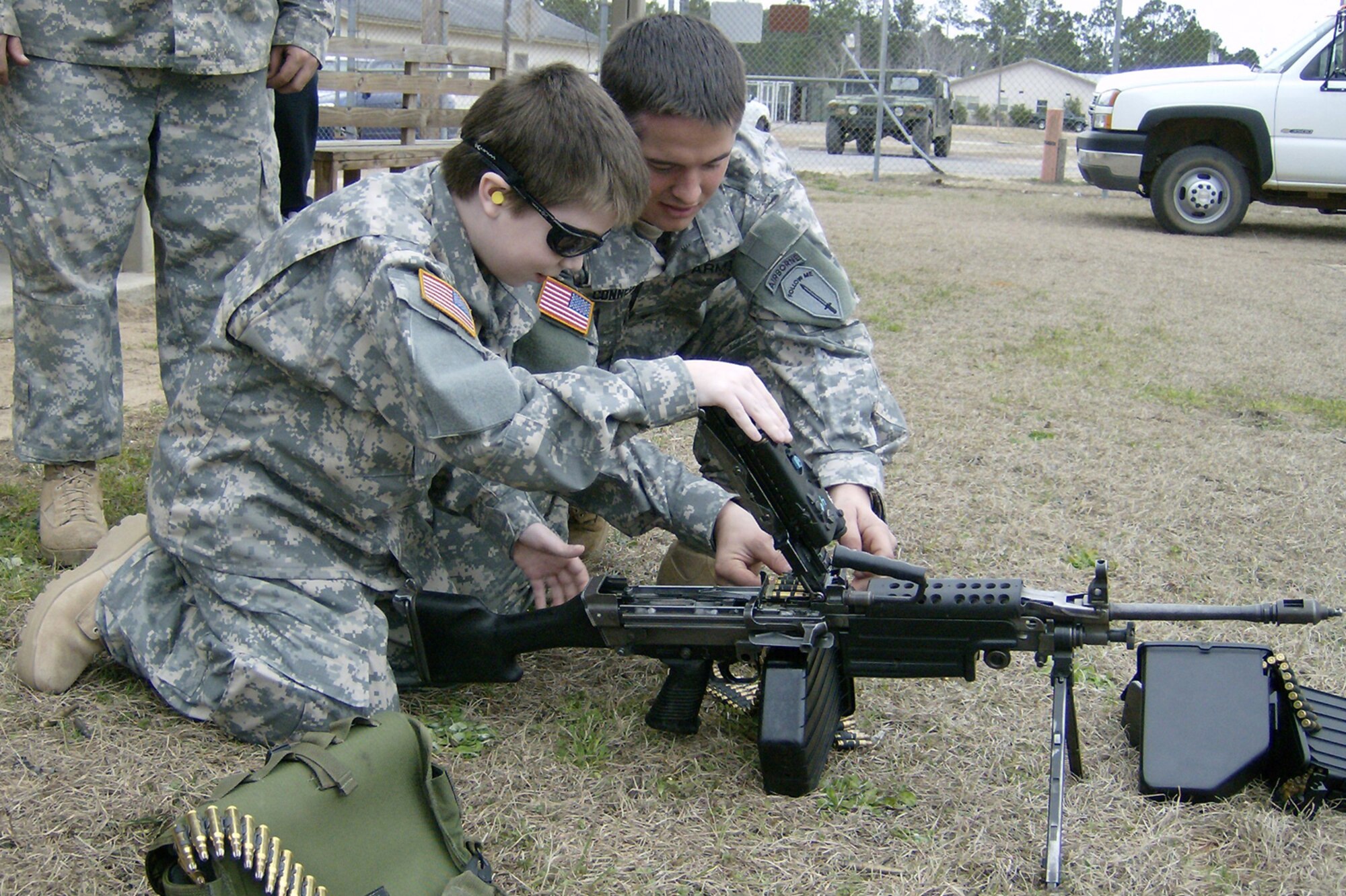 CAMP RUDDER, Fla. -- U.S. Army Spc. Kipper Connell, 6th Ranger Training Battalion armorer, help Riley Woina, 14, from Connecticut, load a M-249 Feb 20. Riley, diagnosed with cystic fibrosis, was granted a week with the 6th Ranger Training Battalion and Eglin Airmen through the Make-A-Wish Foundation Feb. 19-24. (U.S Army photo by Army Capt. Jeremiah Cordovano)