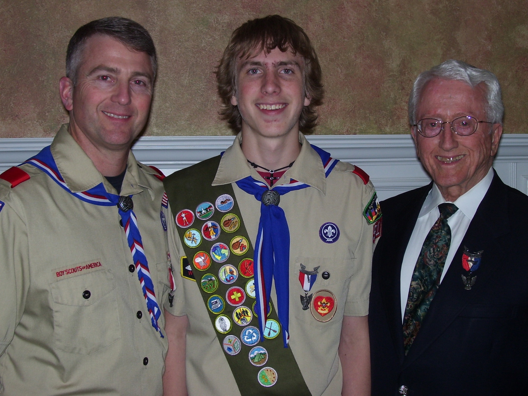 From left Col. Charles W. Williamson III, Headquarters Air Intelligence Agency staff judge advocate, stands with his son, Charles W. "Chip" WIlliamson IV, 17, and his father Charles W. Williamson Jr., after his son was presented the rank of Eagle Scout in a Court of Honor Feb. 23 at Westover Hills Assembly of God church in San Antonio, Texas.  Chip became the third generation in his family to join the top five percent of all boys who join the Boy Scouts. (Photo by Megan Williamson)