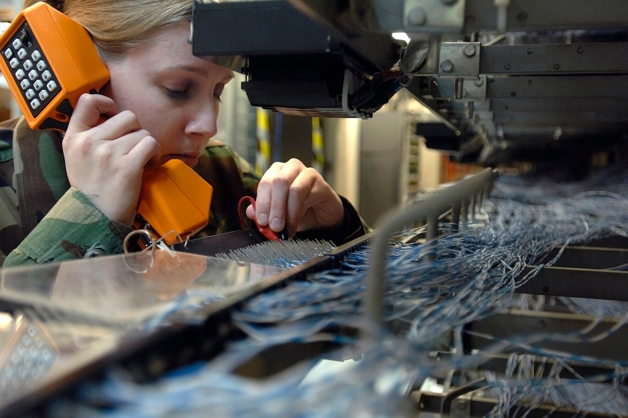 Senior Airman Erin Gilmore, a voice network systems journeyman, uses a wrap tool to terminate a jumper cable telephone wire to an line equipment number Feb. 21 at Langley Air Force Base, Va. More than 22,000 wires connect the many telephones on Langley AFB. Airman Gilmore is assigned to the 1st Communications Squadron. (U.S Air Force photo/Staff Sgt. Eric T. Sheler)