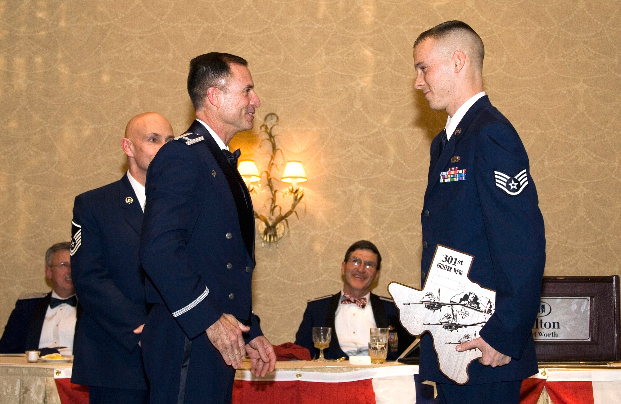 Staff Sgt. Jared Bowen, 301st Aircraft Maintenance Squadron and 301st Fighter Wing Airman of the Year 2006, receives his first of many recognition memorabilia from Col. Kevin Pottinger, 301st FW commander, during the wing's Inaugural Awards Banquet Feb. 3. See page 3 for more banquet photo coverage. (U.S. Air Force Photo/Staff Sgt. Jason Costantino)