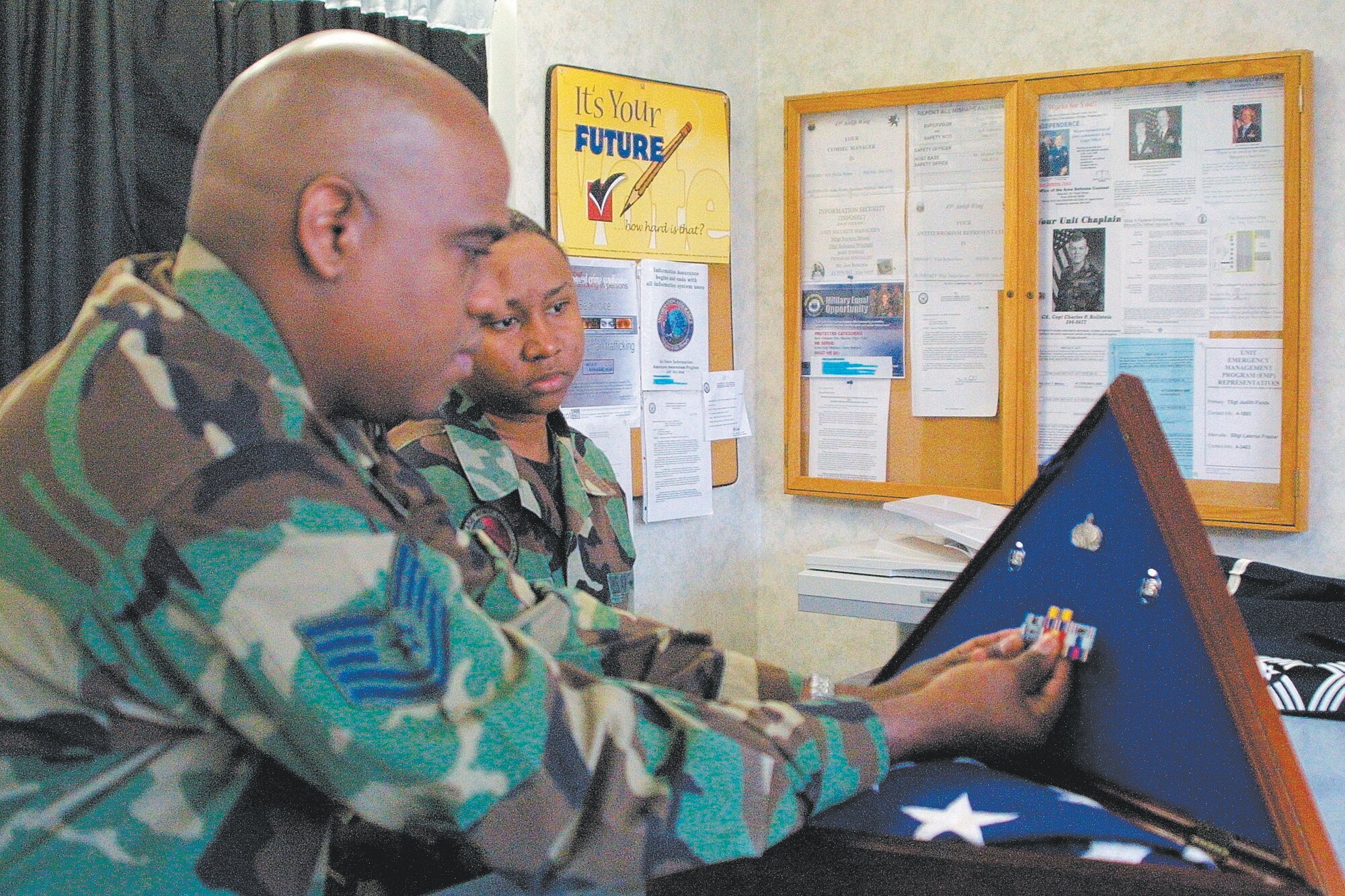 Tech, Sgt. Stan Byron, 43rd Services Squadron Honor Guard NCOIC, demonstrates how to put a shadow box together. The displays, similar to the example at left, are given to spouses and parents of deceased Airmen.