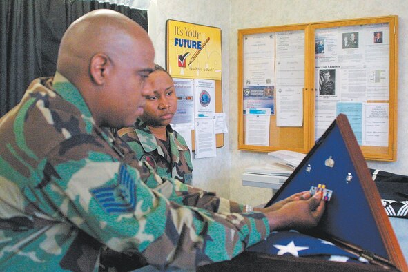 Tech, Sgt. Stan Byron, 43rd Services Squadron Honor Guard NCOIC, demonstrates how to put a shadow box together. The displays, similar to the example at left, are given to spouses and parents of deceased Airmen.