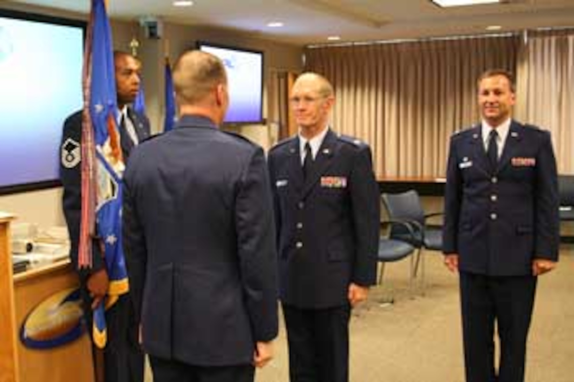After Colonel Jeffrey Turcotte relinquishes command of AFOSR, Air Force Research Laboratory Vice Commander Colonel Scott Coale, begins the action to hand the reins of AFOSR to incoming commander Colonel Michael Hatfield. (Air Force photo by Steve Tarver.)