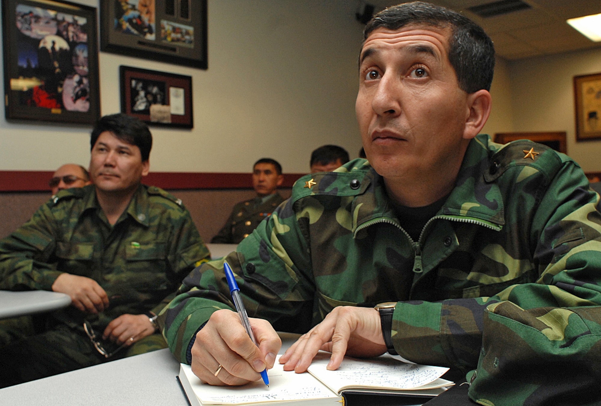 Foreign military visitors from Turkmenistan take notes during a commandant?s brief conducted by Tech. Sgt. Bobbie Ben from the pararescue school here. Many foreign military officials spent time at Kirtland touring everything from the 58th Special Operations Wing to the Base Exchange Feb. 13-14. (U.S. Air Force photo by Todd Berenger)