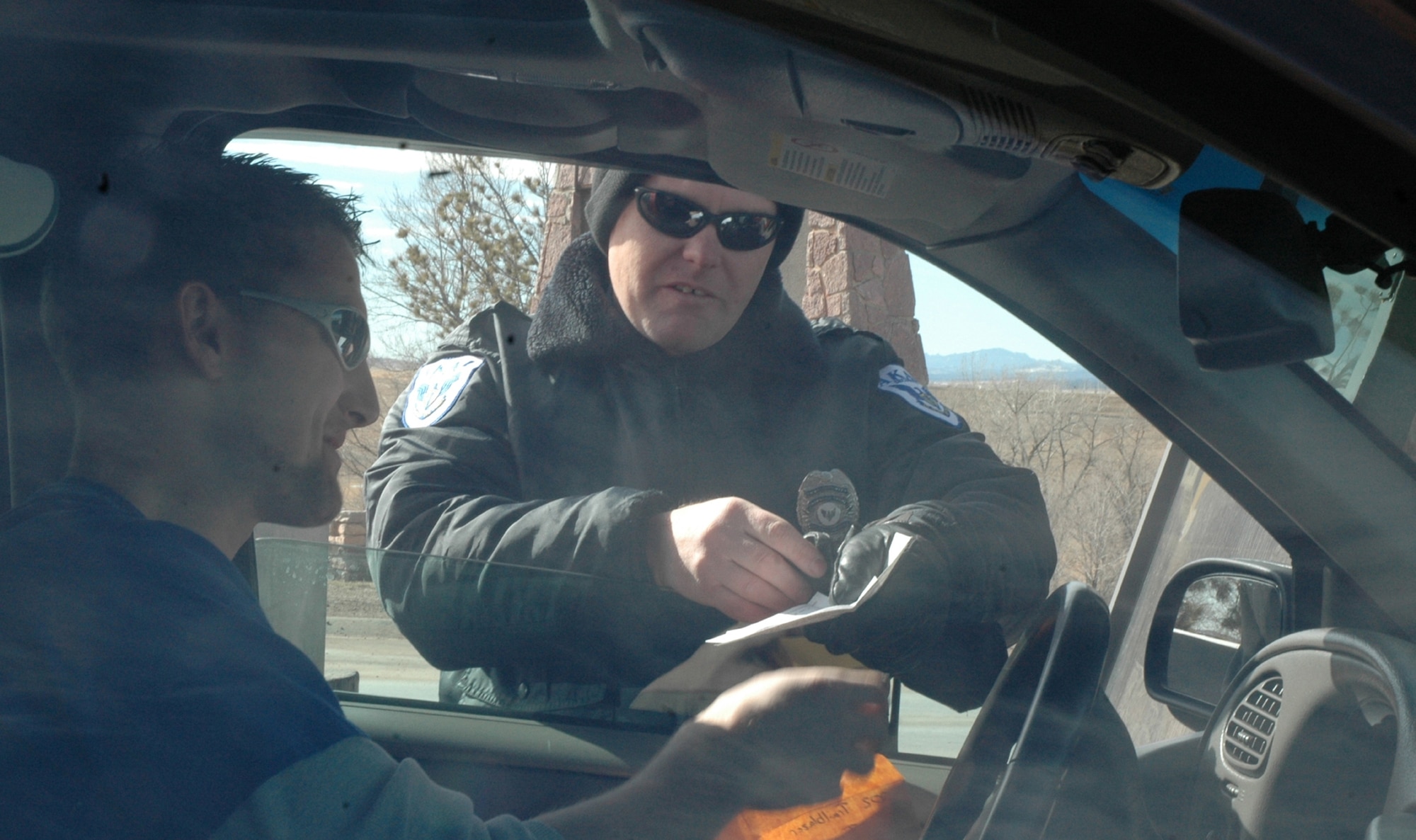 Don Dillon, AKAL security officer, checks the insurance and vehicle registration of an Ellsworth driver prior to letting him on base. Effective Feb. 7, Ellsworth no longer registers privately owned vehicles on base or distributes the Department of Defense Form 2220/DoD Vehicle Registration Decal. All Air Force bases have been directed to make the change by March 15. The initiative is expected to save the Air Force more than $700,000 annually. (U.S. Air Force photo\Senior Airman Josh Moshier)