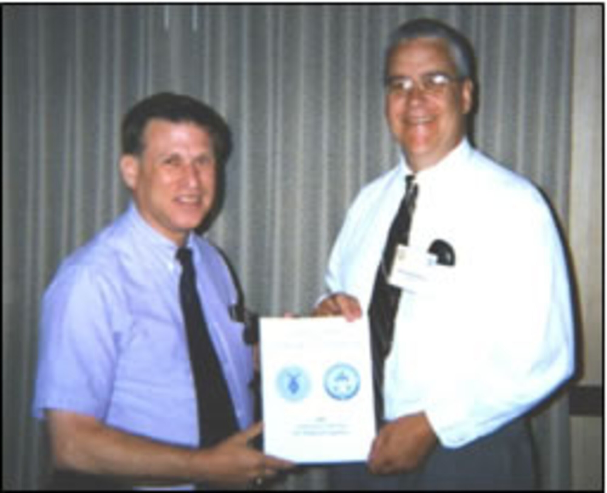 Doctors Tishkoff, left, and McNesby, who co-hosted the research review, display the program guide.