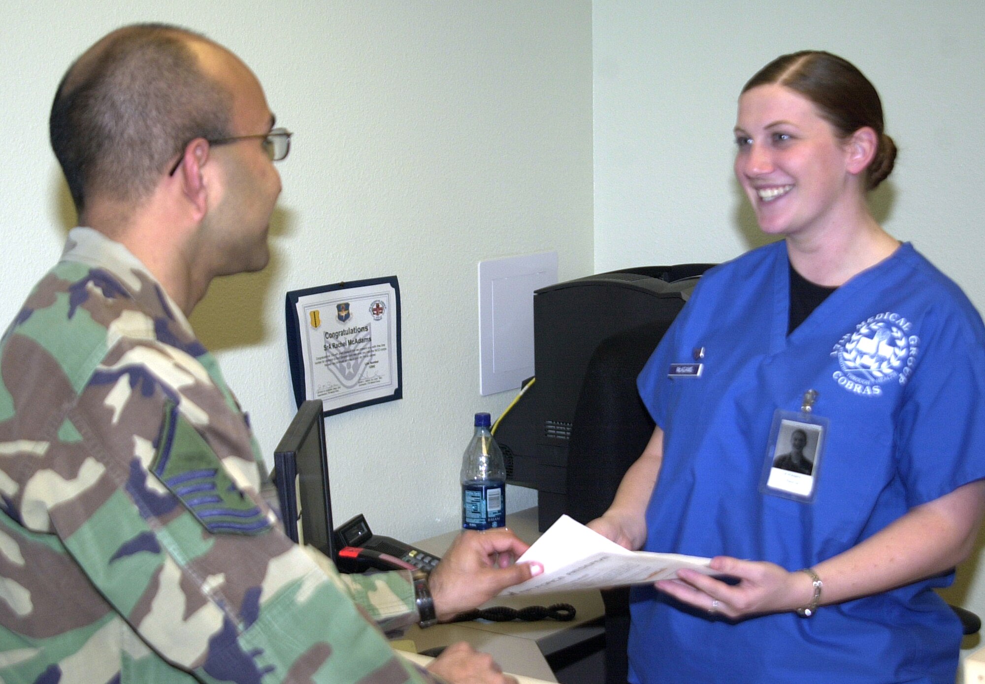 Senior Airman Rachel McAdams (right), a commander’s support staff technician with the 17th Medical Group, helps a customer with paperwork Tuesday. Airman McAdams was recently recognized for her volunteer work with Big Brothers Big Sisters of San Angelo, where she works one-on-one as a mentor for her 14-year-old “little sister.” (U.S. Air Force photo by Airman 1st Class Stephen Musal)