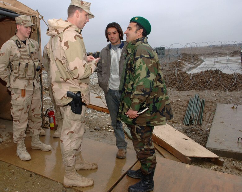 Maj. Corey Ramsby discusses communications infrastructure with Afghan army air corps officers Feb. 20 during a tour of the airfield at Bagram Air Base, Afghanistan. Major Corey is the 54th Expeditionary Combat Communications Squadron commander. (U.S. Air Force photo/Staff Sgt. Kevin Tomko)