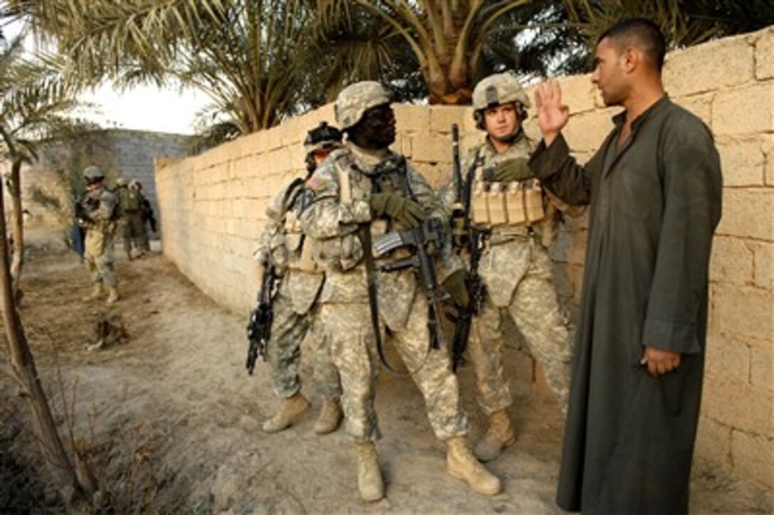 U.S. Army Spec. Angel, linguist, and 2nd Lt. Scott Siggens assigned to Delta Company, 1st Cavalry Division, 12th Infantry Regiment, question locals during a routine foot patrol in Khalis, Iraq, on Feb. 23, 2007.
