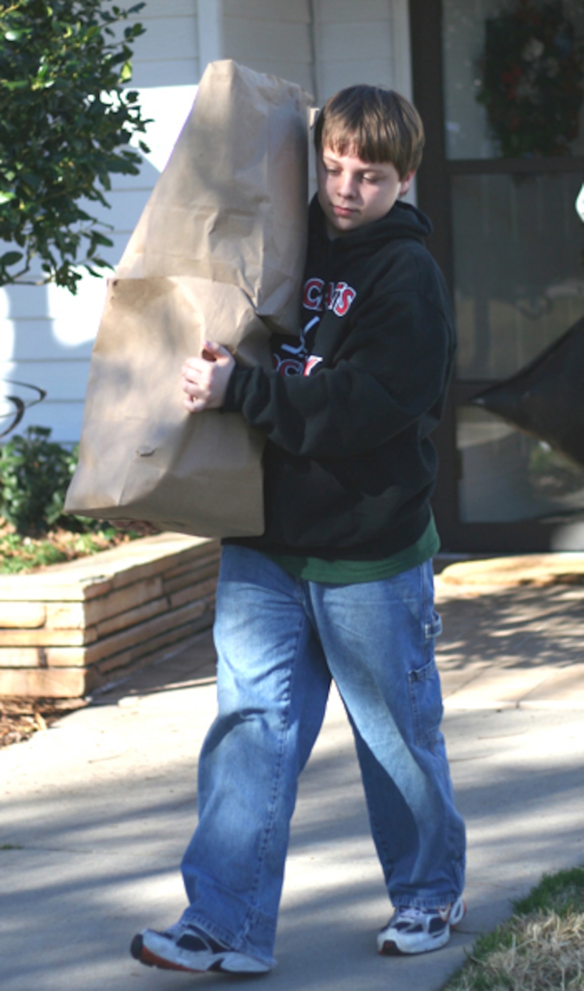 Bailey King, 12, carries donations to a waiting vehicle Feb. 24 during an Airman's Attice Drive. The drive was organized by Neil Kendall to help replenish the Attic's inventory for Airmen E-5 and below. (U.S. Air Force photo/Adrian McCandless)