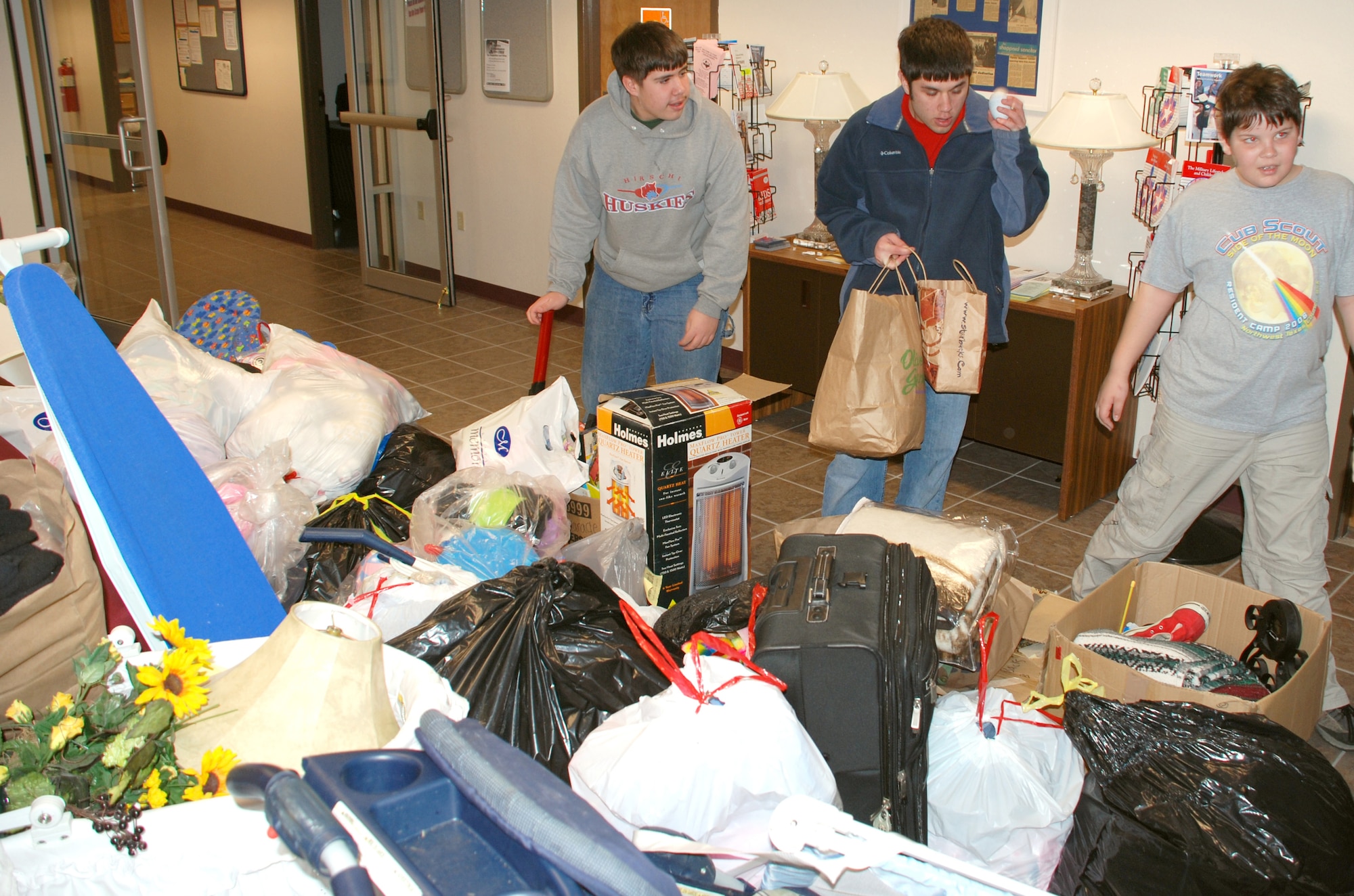 Jared and Andrew Blakeman from Boy Scout Troop 232 and Alex Karabel from Cub Scout Pack 232, sort through some of the donated items gathered Feb. 24 during their Airman's Attic collection drive. The donations filled the lobby of the Airman and Family Readiness Flight's main lobby. (U.S. Air Force photo/Tech. Sgt. Jennifer Isom)