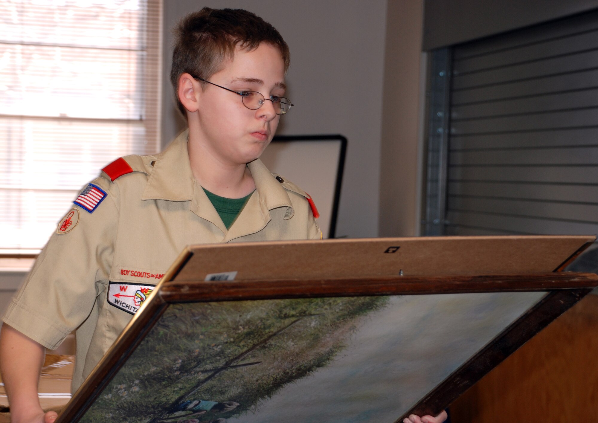 Erik Price, the assistant senior patrol leader for Boy Scout troop 232, sorts through some donated items gathered by the troop Feb. 24 during their Airman's Attic collection drive. (U.S. Air Force photo/Tech. Sgt. Jennifer Isom)