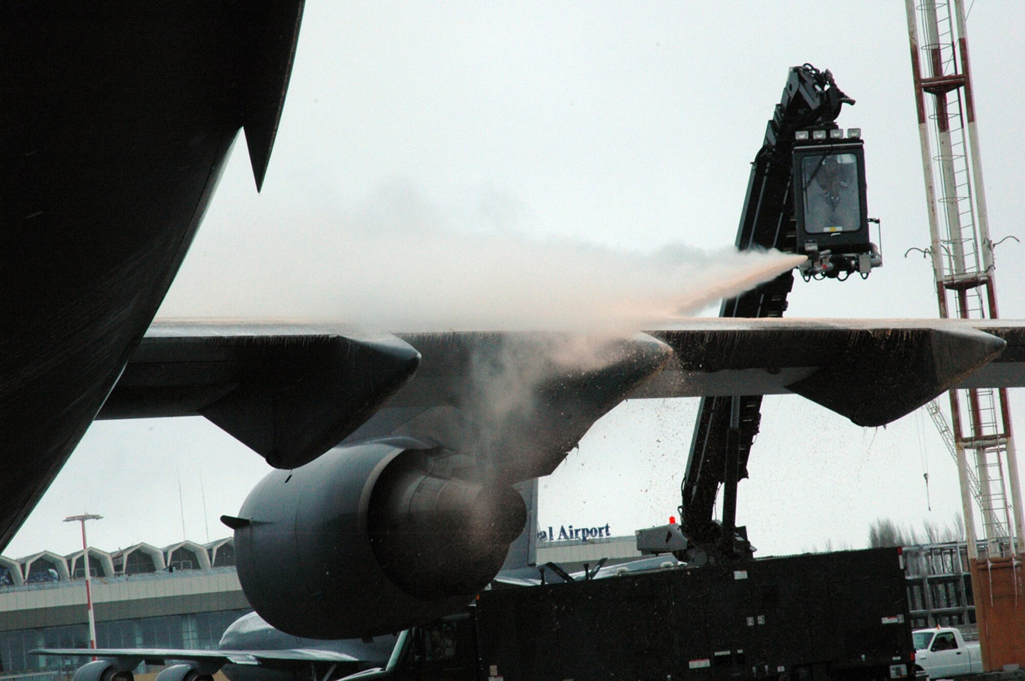 Airman 1st Class David Rosas de-ices a C-17 Globemaster III Feb. 20 prior to an airlift mission.  Airman Rosas' de-icing cabin is suspended from the end of a 80-foot lift truck.  He is with the 817th Expeditionary Airlift Squadron and is deployed from the 62nd Aircraft Maintenance Squadron at McChord Air Force Base, Wash.  (U.S. Air Force Photo/Master Sgt. Daniel Nathaniel)