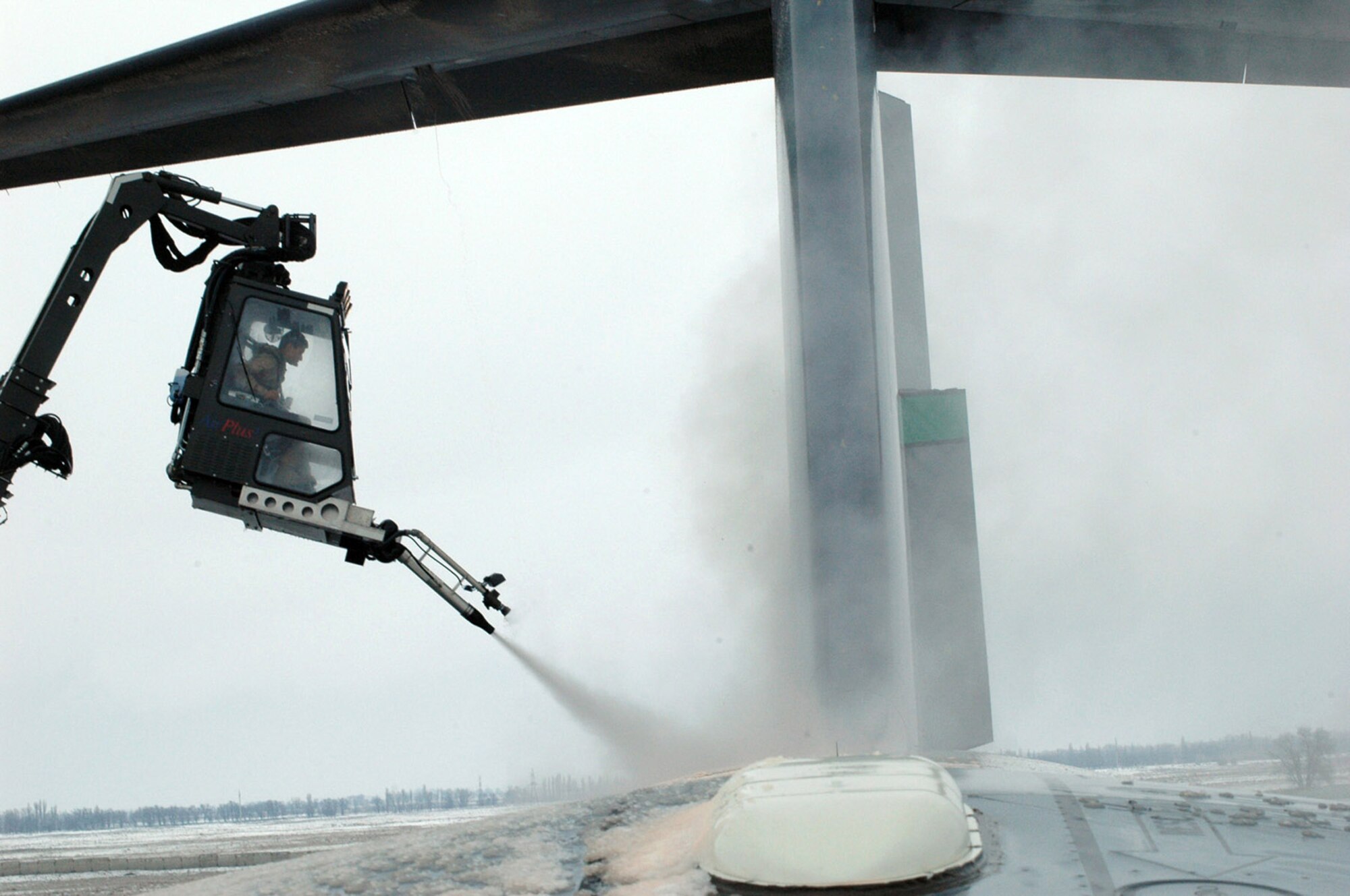 Airman 1st Class David Rosas de-ices a C-17 Globemaster III Feb. 20 prior to an airlift mission.  Airman Rosas' de-icing cabin is suspended from the end of a 80-foot lift truck.  He is with the 817th Expeditionary Airlift Squadron and is deployed from the 62nd Aircraft Maintenance Squadron at McChord Air Force Base, Wash.  (U.S. Air Force Photo/Master Sgt. Daniel Nathaniel)