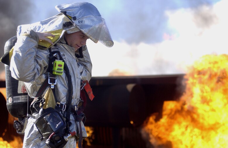 Senior Airman Keith Armour, a firefighter from the 30th Civil Engineer Squadron on Vandenberg, puts on his fire helmet during a training excercise on Feb. 13. Airman Armour just recently got back from a deployment in Iraq where he used this training in real-world situations. (U.S. Air Force photo by Airman Jonathan Olds)