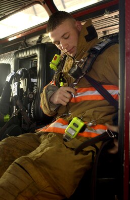 Senior Airman Keith Armour, a firefighter from the 30th Civil Engineer Squadron on Vandenberg, straps into the back seat of a fire engine during a training excercise on Feb. 13. Airman Armour just recently got back from a deployment in Iraq where he used this training in real-world situations. (U.S. Air Force photo by Airman Jonathan Olds)