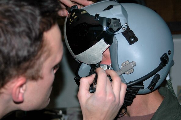 Capt. Lee Dewald, 4th Fighter Squadron pilot, gets an individual fit for his new helmet to fly with the CCIP jets. Senior Airman Mark Fredrickson pencils in around the edges to accuratley measure where the visor should be shaved off in order to get a perfect fit. Airman Fredrickson is a life support technician with the 4th FS. (Photo by Airman 1st Class Stefanie Torres)