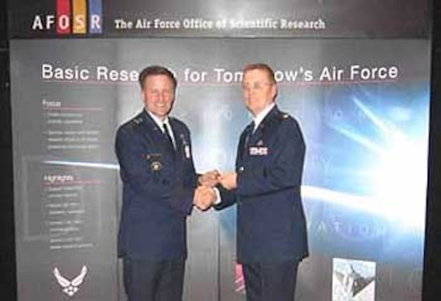 Lt. Col. John Kaplan, Director, Policy and Integration, Air Force Office of Scientific Research (AFOSR) (right) presents Maj. General William T. Lord, Director, Services and Integration, Secretary of the Air Force of Warfighting Integration and Chief Information Officer, the Pentagon, Washington, D.C., with an AFOSR coin in appreciation for Maj. General Lord’s participation as a keynote speaker at the 44th National Junior Science and Humanities Symposium held April 26-30 in Albuquerque, New Mexico. (Air Force photo by Erin Crawley)