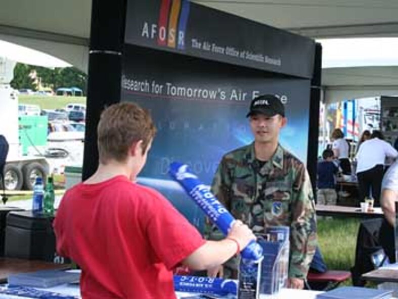 AFOSR Deputy Director of Policy and Integration, Capt. Dan Adcock, talks with a visitor to the AFOSR information booth May 20 at Team America Rocketry Challenge, The Plains, Va. Hundreds of students, parents, and teachers visited the booth throughout the day. ( U.S. Air Force Photo by Erin Crawley)